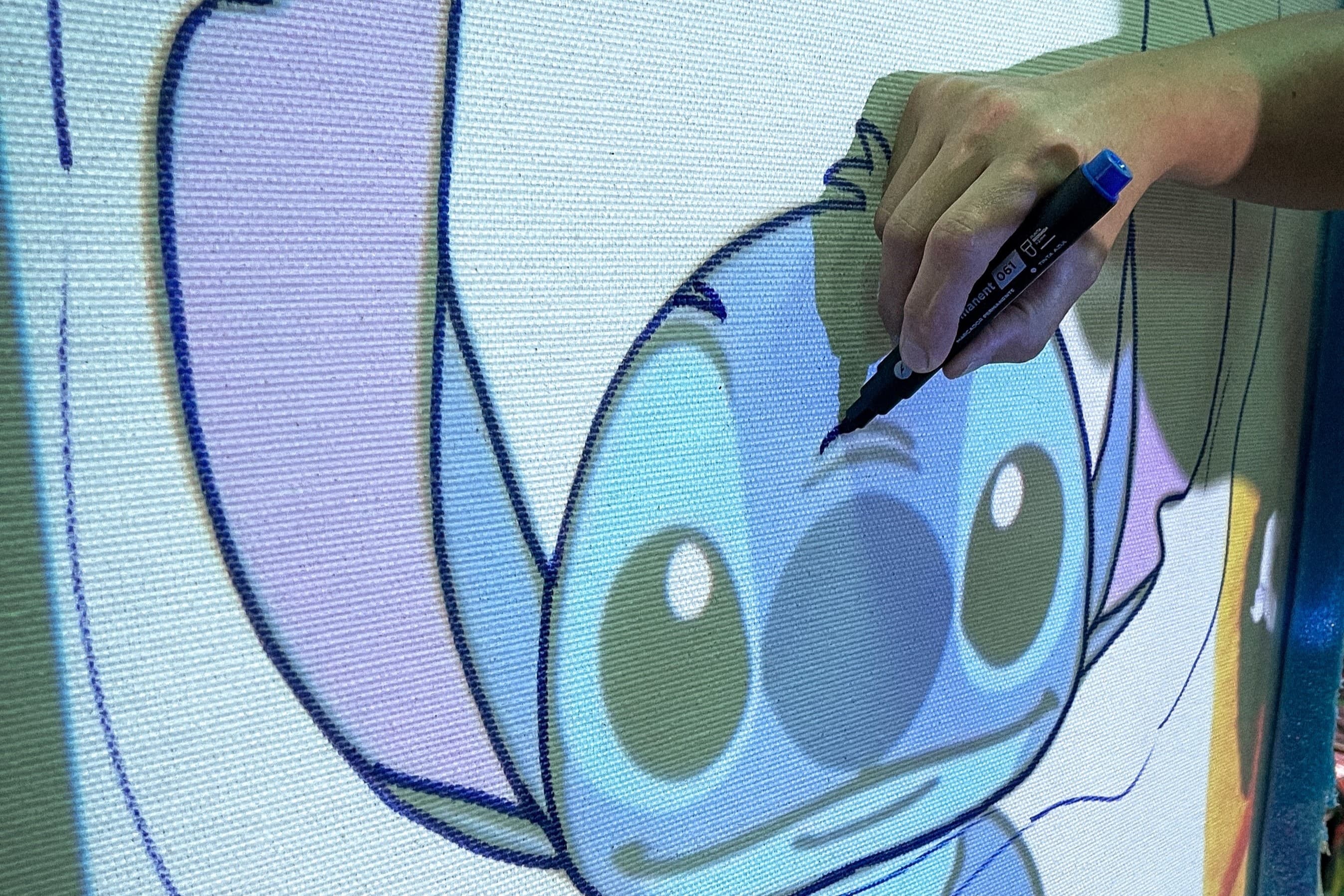 Mano trazando un patrón de Stitch con marcador sobre tela de tufting