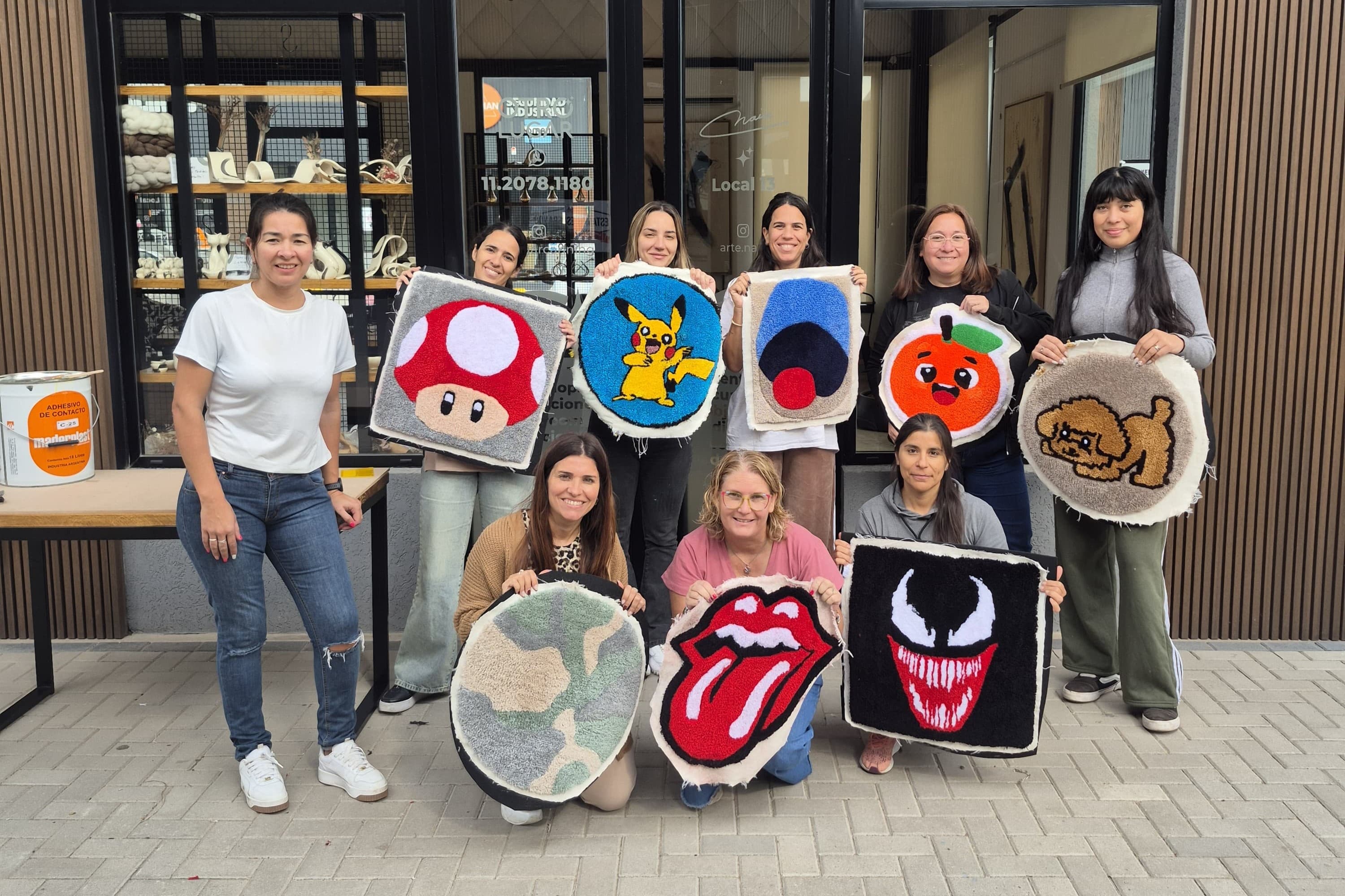 Grupo de alumnas mostrando sus alfombras de tufting terminadas en taller presencial Maxitufting